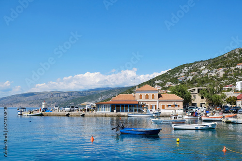 Idyllic view of Sveti Juraj, Croatia. A small quiet port village on the Adriatic with crystal clear water. Port with houses and boats on water.