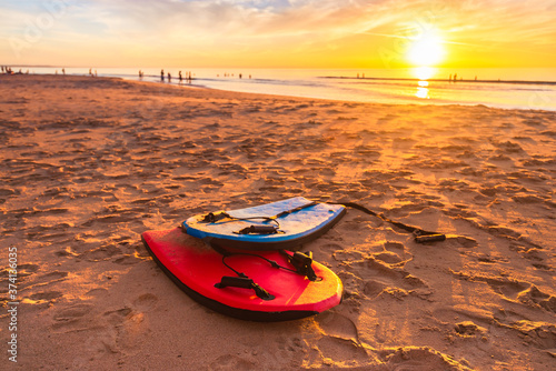 Tableau sur toile Swimming bodyboards on the beach at beautiful sunset on a warm summer evening, S