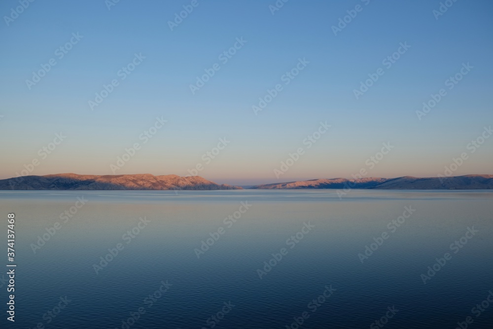 Idyllic view of rocky islands on horizon at dawn.