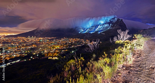 Table mountain with the 'Table Cloth' mist overlooking Cape Town in South Africa at dusk