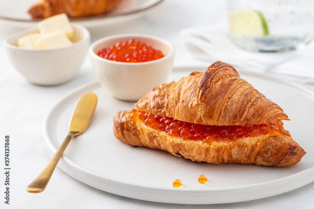 Red caviar and croissant for breakfast, selective focus. Luxury breakfast. Red caviar and croissant for breakfast, selective focus. Luxury breakfast.