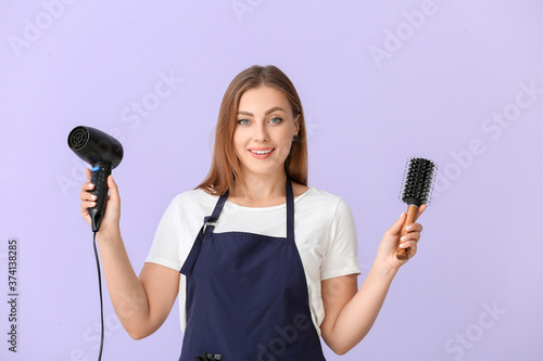 Female hairdresser on color background