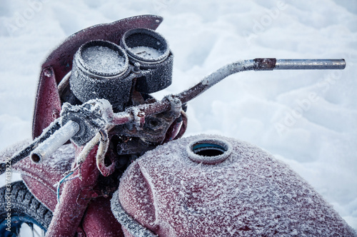 Old motorcycle covered with frost