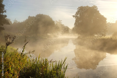 Early morning mist over the meadows on the River Wey in Godalming, Surrey, on a cold autumn morning.
