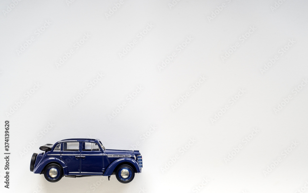 Model of a blue vintage children's car on white isolate, place for text