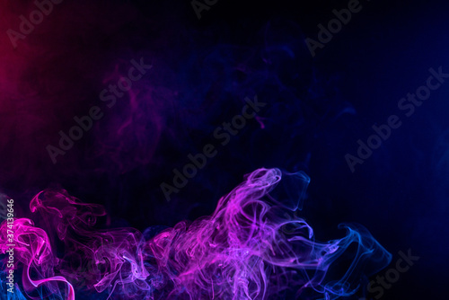 Conceptual image of multi-colored smoke isolated on dark black background  Halloween design element.