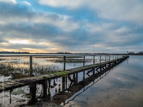 sun setting over an old wooden jetty © Penny