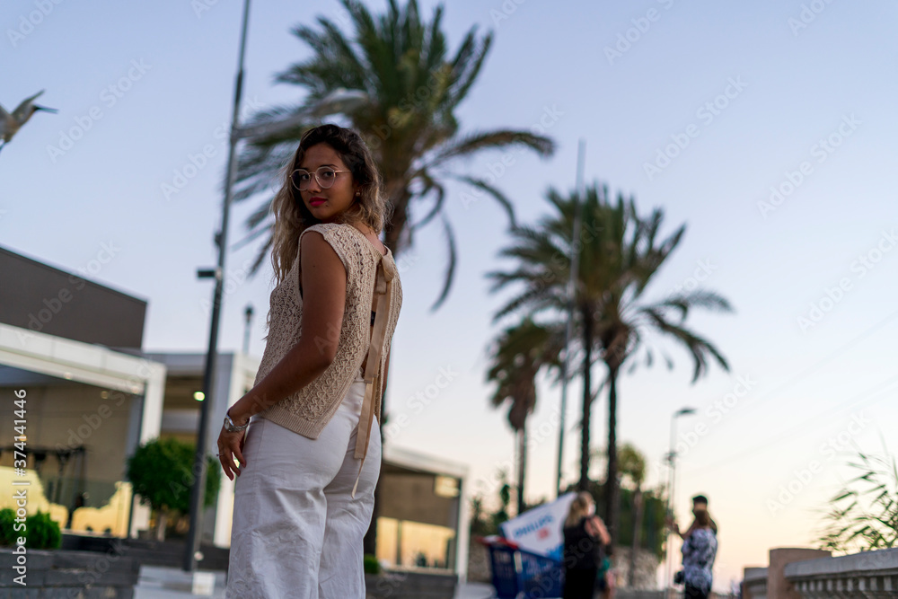 Chica joven y guapa junto a palmeras de compras