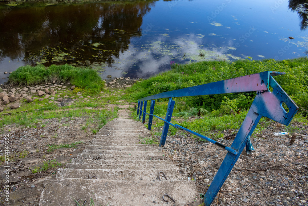 Stone stairs with iron railings leading to the river Stone stairs with iron railings leading to the river