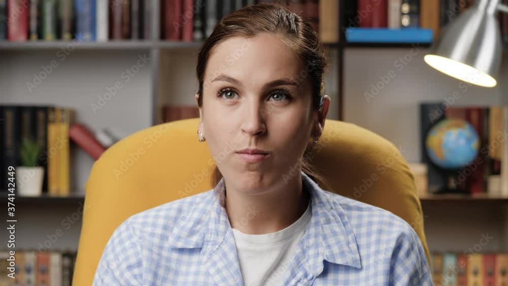 Woman is watching TV and eating popcorn. Attractive girl in room in evening alone watches TV and eats popcorn Woman is watching TV and eating popcorn. Attractive girl in room in evening alone watches TV and eats popcorn