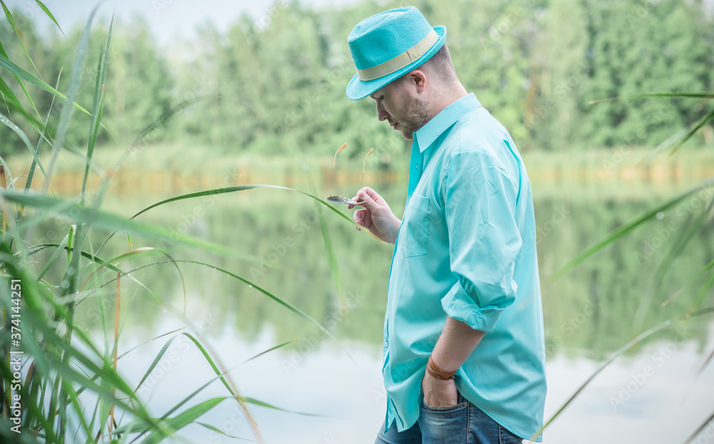 Young guy in turquoise shirt fashion outfit for men, clothes concept. Man  rest at nature in fancy style Stock Photo