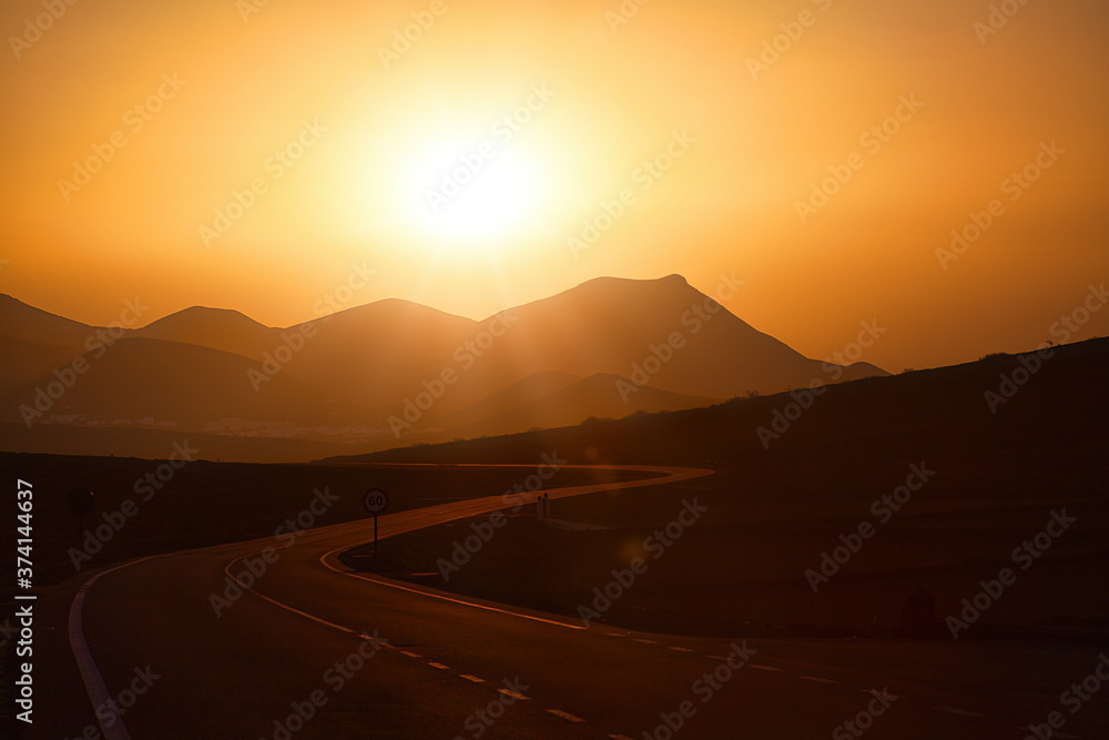 Auf der Kanarischen Insel Lanzarote führt diese Straße dem Sonnenuntergang entgegen zu den Vulkanen