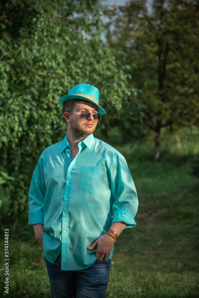 Young guy in turquoise shirt fashion outfit for men, clothes concept. Man  rest at nature in fancy style Stock Photo | Adobe Stock