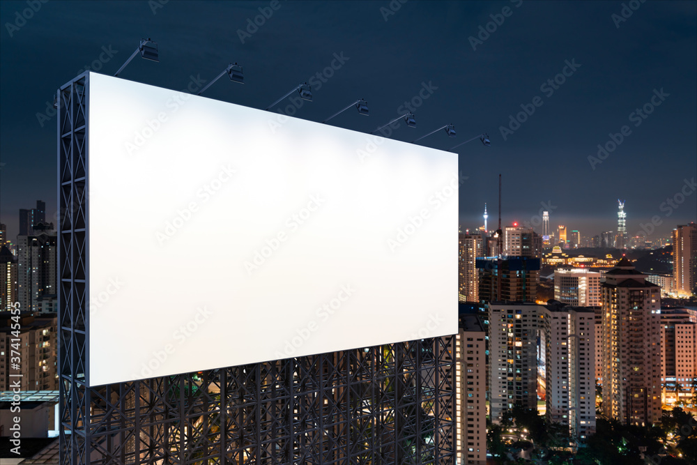 Obraz premium Blank white road billboard with KL cityscape background at night time. Street advertising poster, mock up, 3D rendering. Side view. The concept of marketing communication to promote or sell idea.