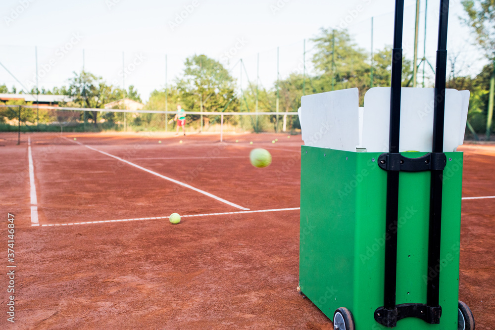 Ball machine on slag tennis court. Stock Photo | Adobe Stock