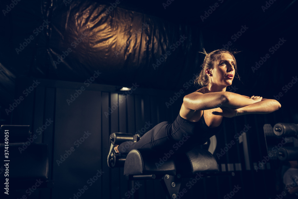 Flexible, strong. Young caucasian female athlete training in gym, doing strength exercises, practicing. Beautiful girl works on her upper and lower body. Fitness, wellness, sport, healthy lifestyle Flexible, strong. Young caucasian female athlete training in gym, doing strength exercises, practicing. Beautiful girl works on her upper and lower body. Fitness, wellness, sport, healthy lifestyle