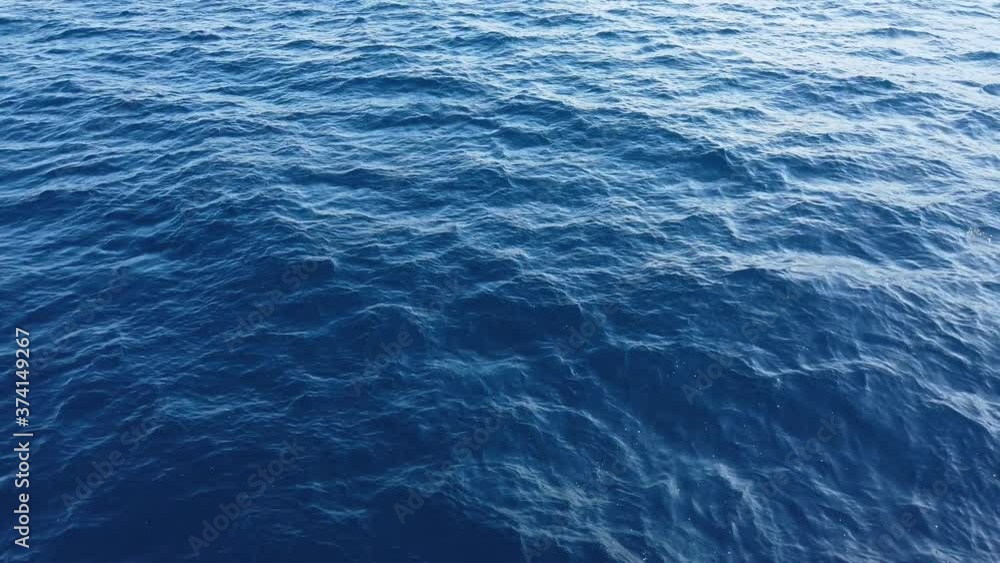 Flight of the camera over the surface of the water. Sea or ocean, faint, light ripples in the blue sea. Flight of the camera over the surface of the water. Sea or ocean, faint, light ripples in the blue sea.