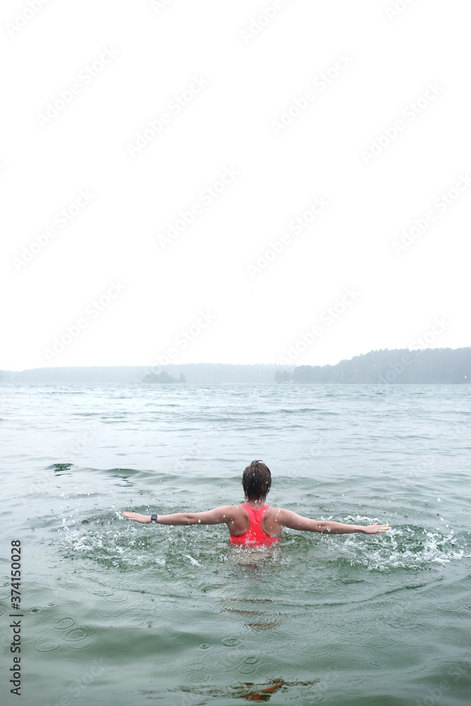 Fototapeta premium Caucasian short hair girl swimming in foggy lake