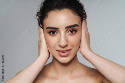 Image of half-naked woman looking at camera and covering her ears