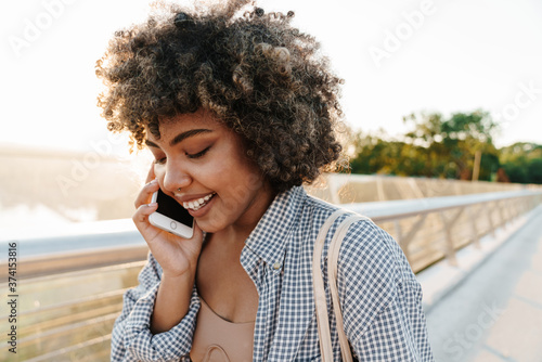 Happy attractive young african girl using mobile phone