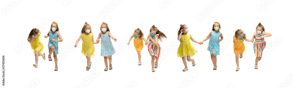Happy 2 little girls wearing protective face mask jumping and running isolated on white background. Looks happy, cheerful, sincere. Copyspace. Childhood, pandemic concept. Healthcare, coronavirus Happy 2 little girls wearing protective face mask jumping and running isolated on white background. Looks happy, cheerful, sincere. Copyspace. Childhood, pandemic concept. Healthcare, coronavirus