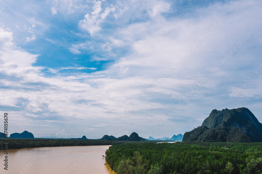 Fototapeta premium Aerial scenery view of mangroves forest, river canals and mountains. Bird's eye view of beautiful panoramic nature landscape of tropical water jungle on Ao Phang Nga bay National Park, Thailand