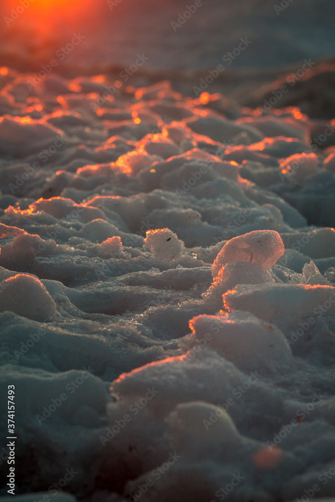 Obraz premium Close up of frozen ice along a beach at sunset in Petoskey Michigan