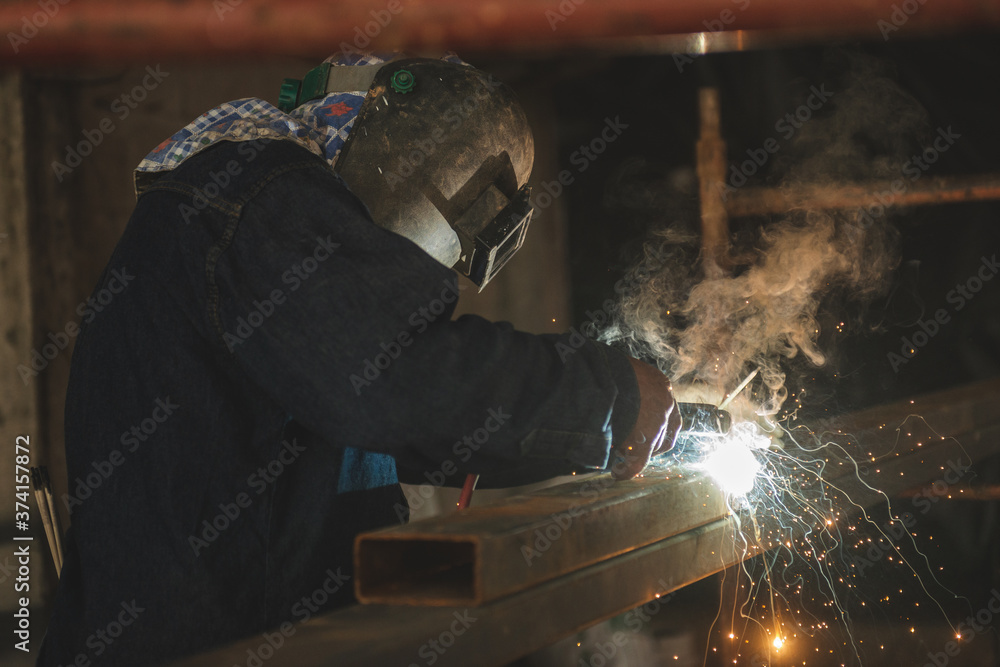 El Oro / Ecuador - 2017 : A welder at his job, welding metal bars together El Oro / Ecuador - 2017 : A welder at his job, welding metal bars together