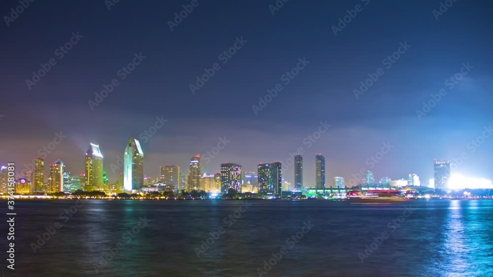 Night timelapse of downtown San Diego, CA skyline viewed from across the water on Coronado Island. Boats pass by in the foreground and a fireworks show is displayed. Night timelapse of downtown San Diego, CA skyline viewed from across the water on Coronado Island. Boats pass by in the foreground and a fireworks show is displayed.