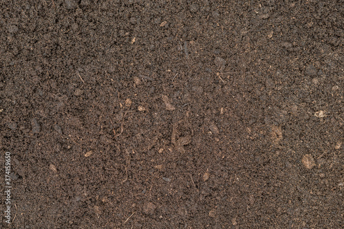 Seamless dark brown compost fertiliser texture background.