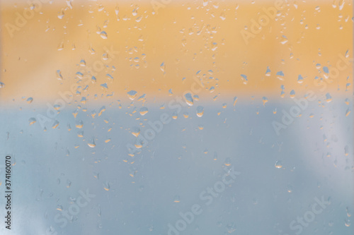 Water rain drops or condensation over blurred orange and blue background. Easy to put over any background