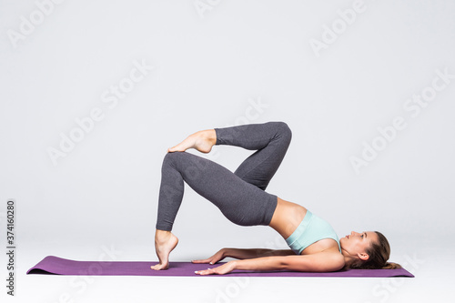 Sporty young woman doing yoga practice isolated on white background