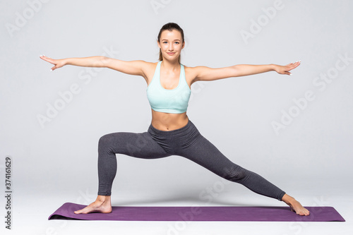 Young attractive woman practicing fitness, standing in lunge exercise, yoga pose, working out wearing sportswear, isolated on white background