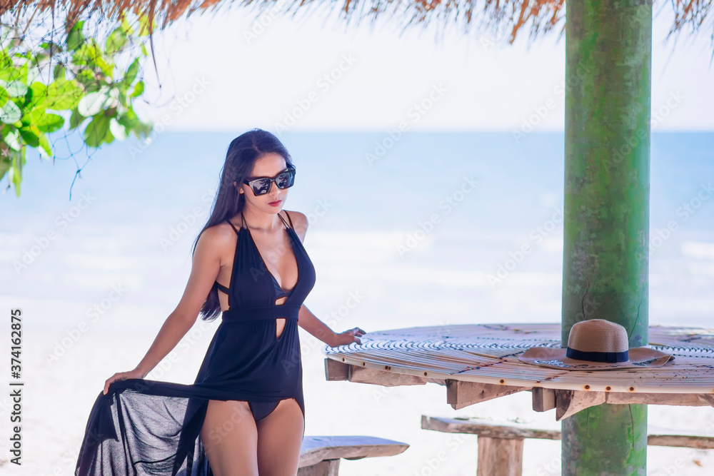 Sexy Asian women wearing bikini for a walk on the beach on vacation in