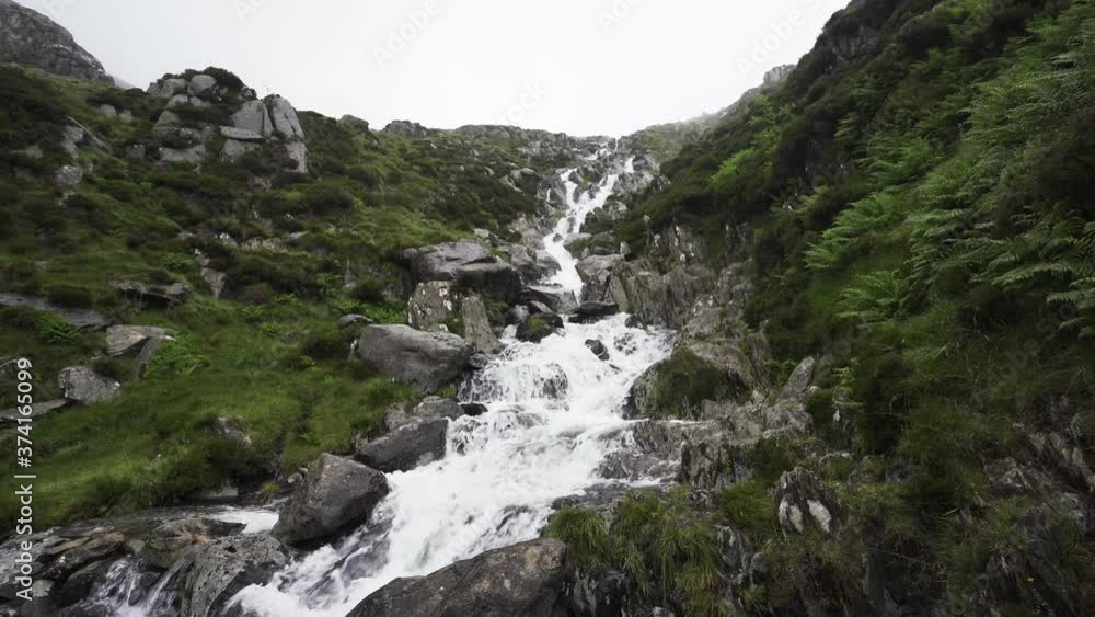 Welsh mountain waterfall in Snowdonia with misty sky Welsh mountain waterfall in Snowdonia with misty sky