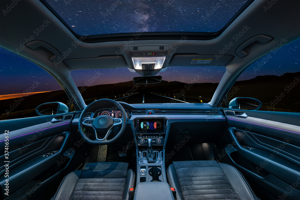  car is in autonomous driving mode with a panoramic glass roof while driving at night in the mountains