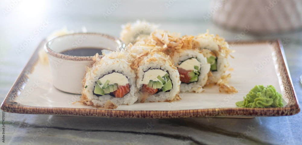 Japanese sushi rolls set with wasabi, ginger and soy sauce served on traditional plate Japanese sushi rolls set with wasabi, ginger and soy sauce served on traditional plate