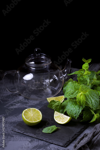 Lime, mint and empty glass tea pot. Ingredients to make tea