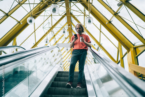 Serious man checking social media using mobile in pedestrian bridge © BullRun