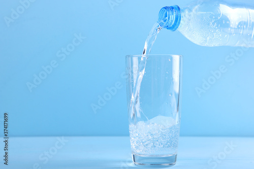 Clear water in a glass and bottle on the table
