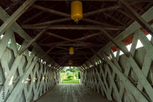Inside view of covered bridge in Madison County, Winterset, Iowa, with trusses, running boards, yellow lights, and light at the end of the tunnel  Royalty free stock photo © seacave