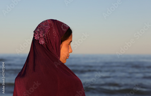 little girl with look at the seashore with a veil on her head