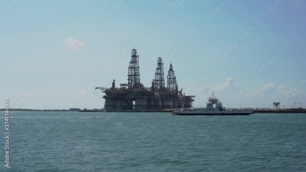 Ferry carrying cars crosses channel in front of oil rig Ferry carrying cars crosses channel in front of oil rig