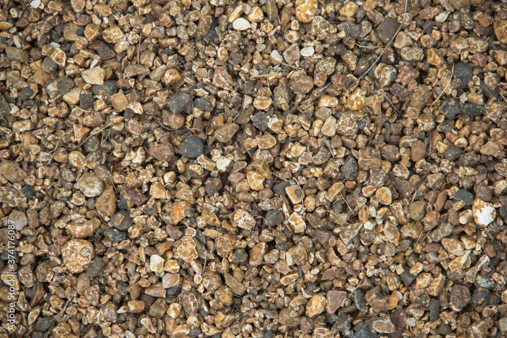 Small stones of seamless texture. Seamless surface texture covered with small dark brown stones. Small stones of seamless texture. Seamless surface texture covered with small dark brown stones.