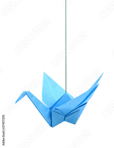 Blue origami bird hanging on white