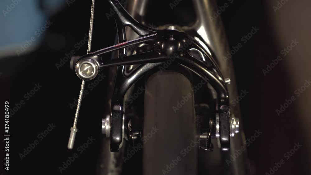 Legs of man are pedaling on stationary bike and rotating wheel closeup
