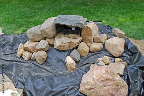 Принти на полотні Rocks being placed in the spillway on top of the vinyl liner for a backyard wate