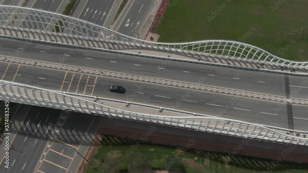 Camera follows black sport car crossing the road junction in Meydan, Dubai. Drone aerial Camera follows black sport car crossing the road junction in Meydan, Dubai. Drone aerial