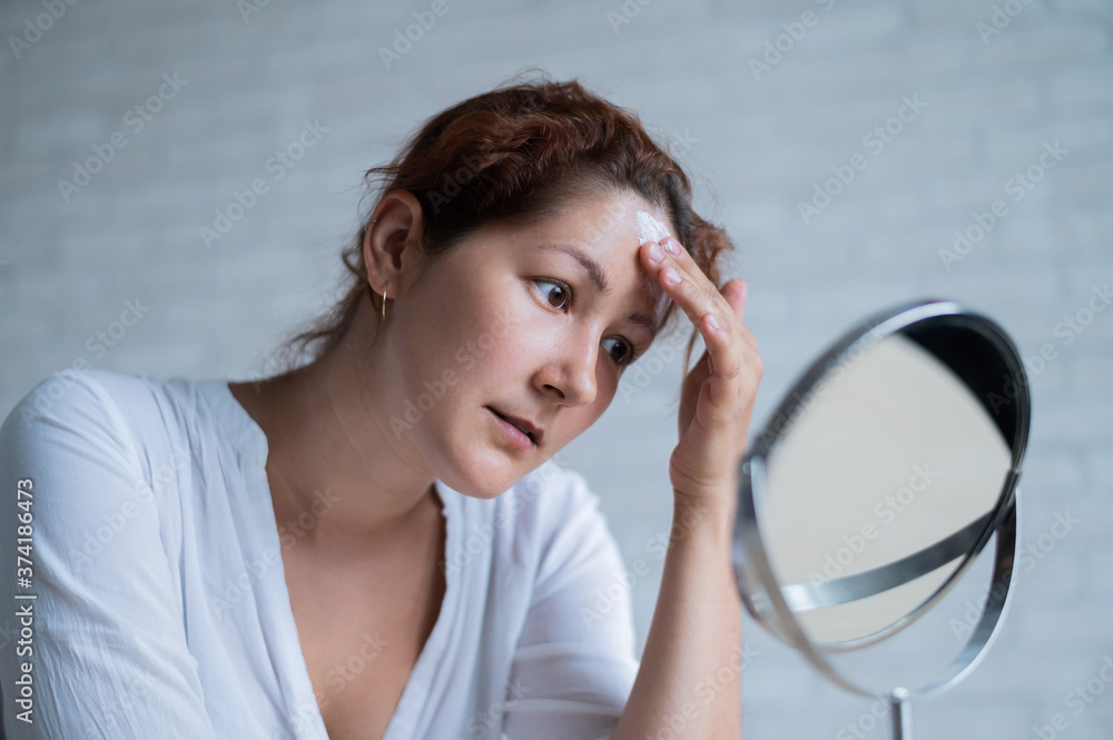 Portrait of a Caucasian woman with vitiligo looks in the mirror Portrait of a Caucasian woman with vitiligo looks in the mirror