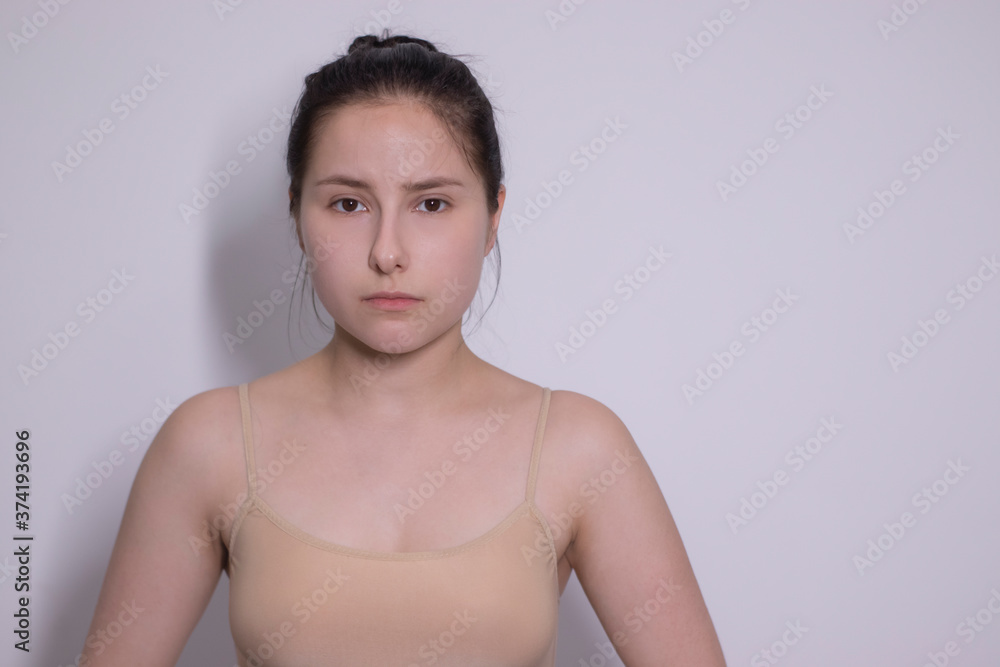 Obraz premium emotional portrait of attractive brunette, actress in a beige undershirt - bodysuit on white background. space for text. High quality photo